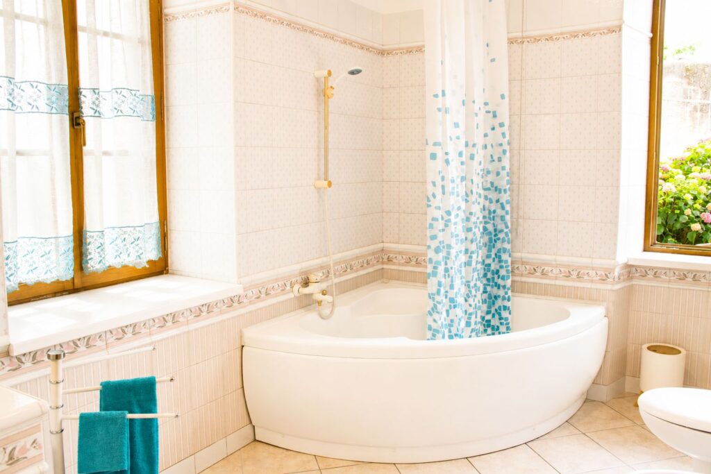 Grande vasca da bagno bianca in un bagno luminoso con finestra.