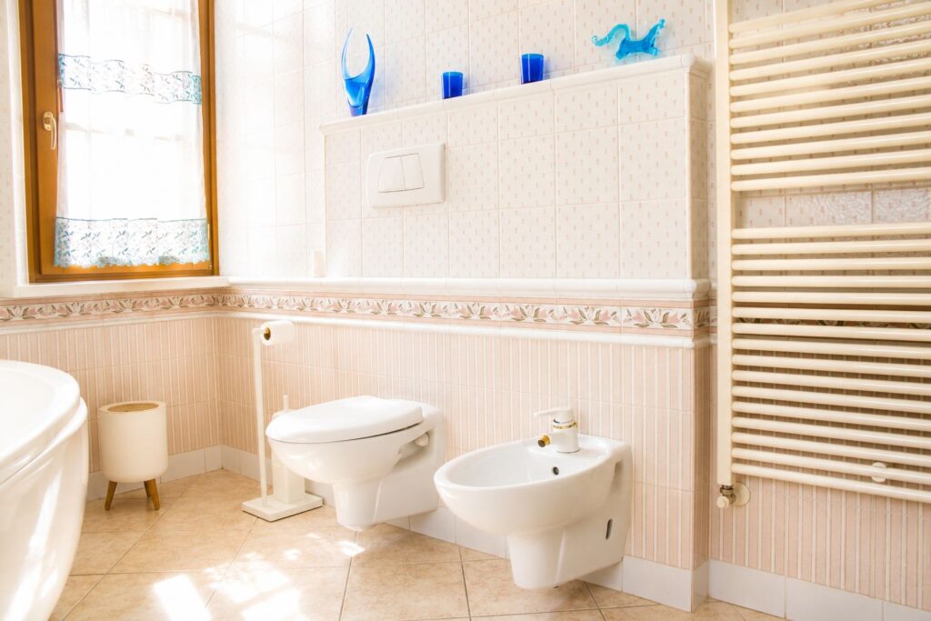 Bagno con vasca, doccia, finestra e finiture in ceramica decorata.