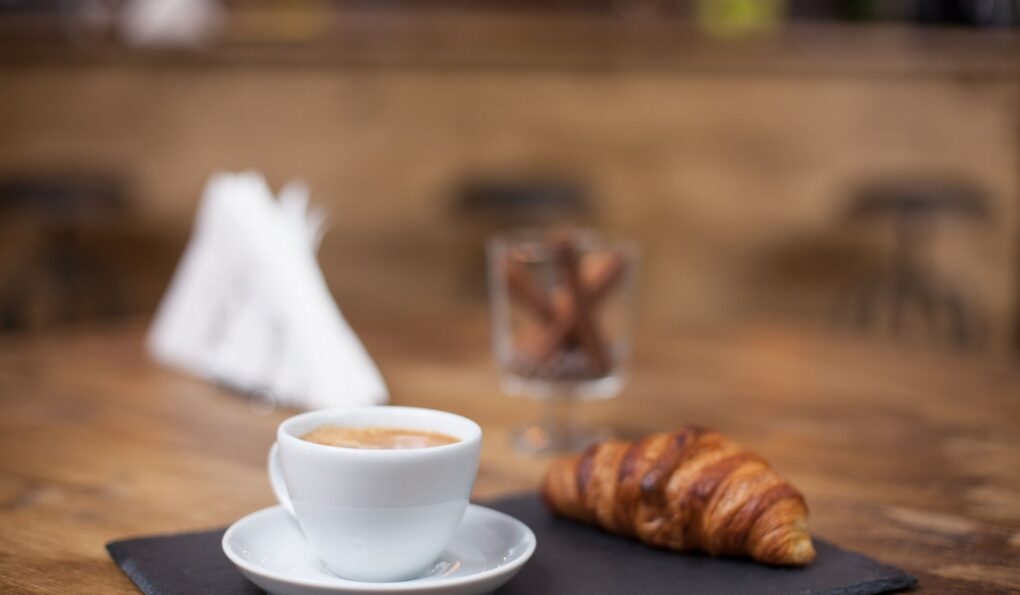 Tazza di caffè e croissant su un tavolo in un bar del Trentino