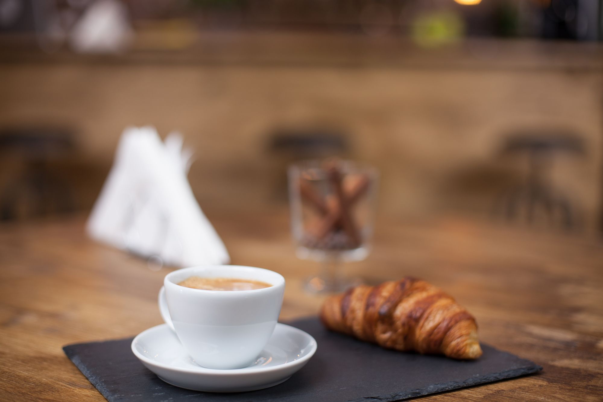 Tazza di caffè e croissant su un tavolo in un bar del Trentino