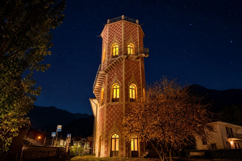 Torre Belvedere illuminata di notte sotto un cielo stellato a Levico Terme